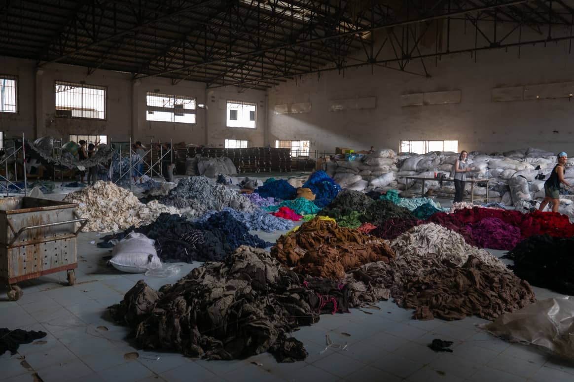 Camboya, clasificando cientos de toneladas de ropa en una fábrica abandonada para una misión social llamada Clothing the Loop. Crédito: Francois Le Nguyen, a través de Unsplash.