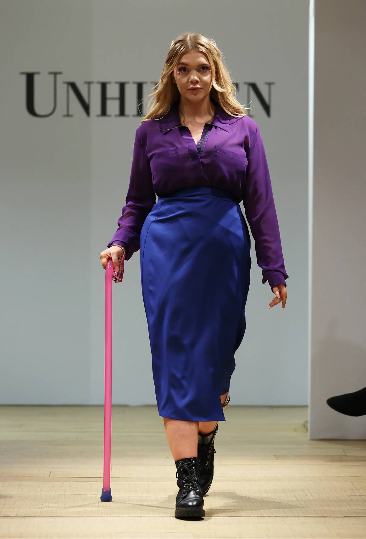 Model with walking cane in wraparound skirt in Unhidden runway show Feb 23
