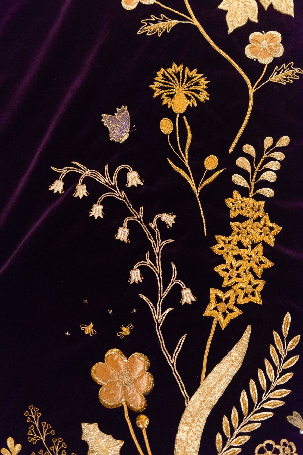 A close-up of the embroidered details on The Queen’s Robe of Estate, showing a butterfly and bees