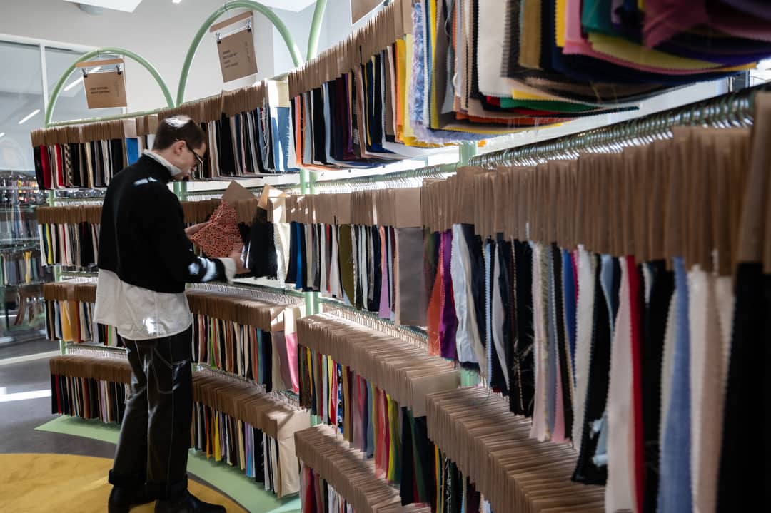 Le styliste espagnol Arturo Obegero regarde des tissus dans la salle d'exposition de Nona Source, qui revend des matériaux provenant des sociétés de mode et de maroquinerie du groupe LVMH, à Paris le 14 mars 2024.