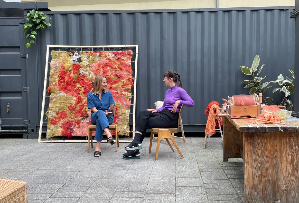 Bild: Hessnatur-Geschäftsführerin Silvia Ebinger spricht mit Textilkünstlerin Stefanie Salzmann über ihre Picknickdecke aus der Wolle der Schwarznasenschafe. / FashionUnited