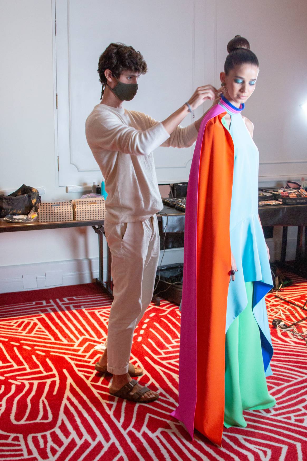 Kris Goyri haciendo ajustes finales en el vestido con la modelo.