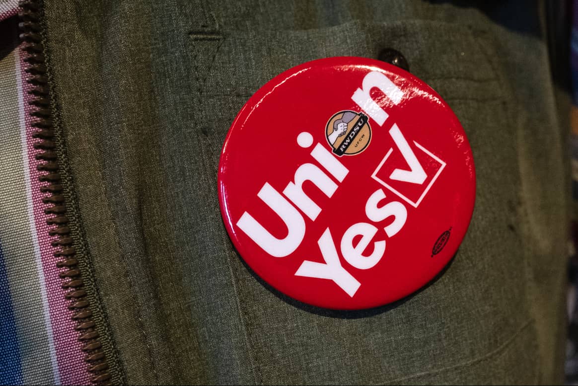 A pro-union button on an REI SoHo store employee’s vest. Image by Jennifer Mason