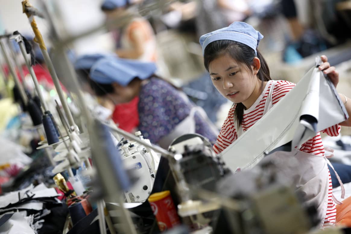 Imagen: Una trabajadora trabaja en una fábrica de ropa textil en Huaibei, provincia de Anhui, este de China, el 1 de septiembre de 2015.  Crédito: Fotografía de Zhengyi Xie / NurPhoto / NurPhoto vía AFP.