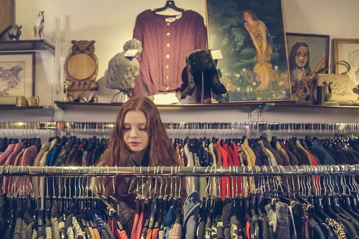 A young woman browsing in a second-hand store.