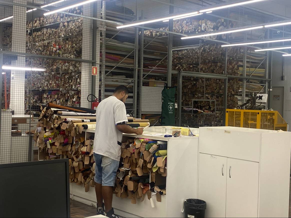 Werknemer in de schoenenfabriek van Arezzo, Brazilië, met rollen leer. Foto: FashionUnited.