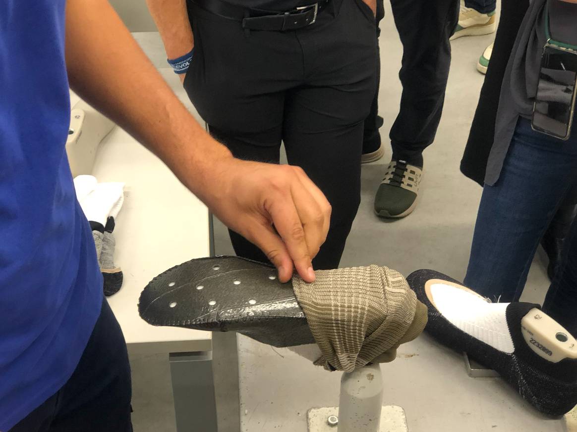 Mitarbeiter verbindet Socke eines Schuhs mit Innenschicht