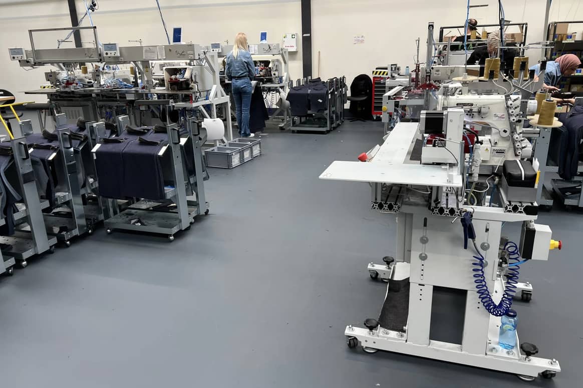 The machine from manufacturer SIP Italy automatically folds the pre-cut parts for pockets before they are then sewn onto the trouser legs. The application of buttons and zippers is also automated at C&A FIT.