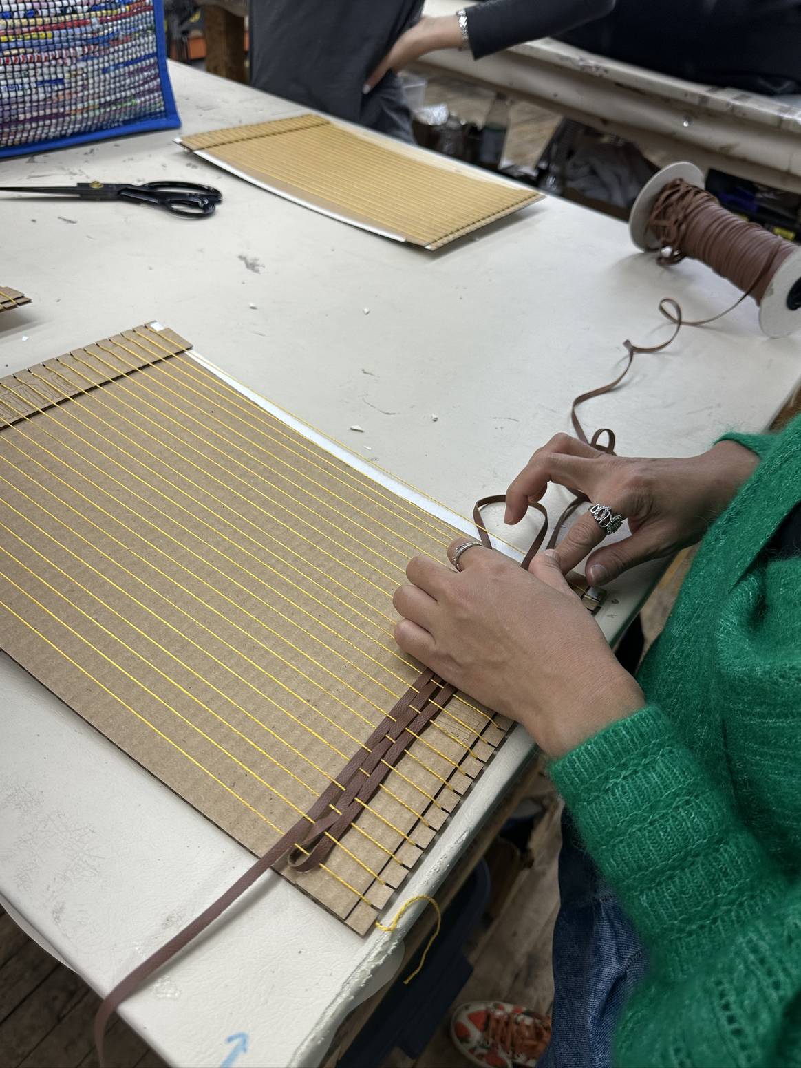 EMiLUX students learn how to weave during workshop at Anybag factory. Credits: Image courtesy of Anybag.