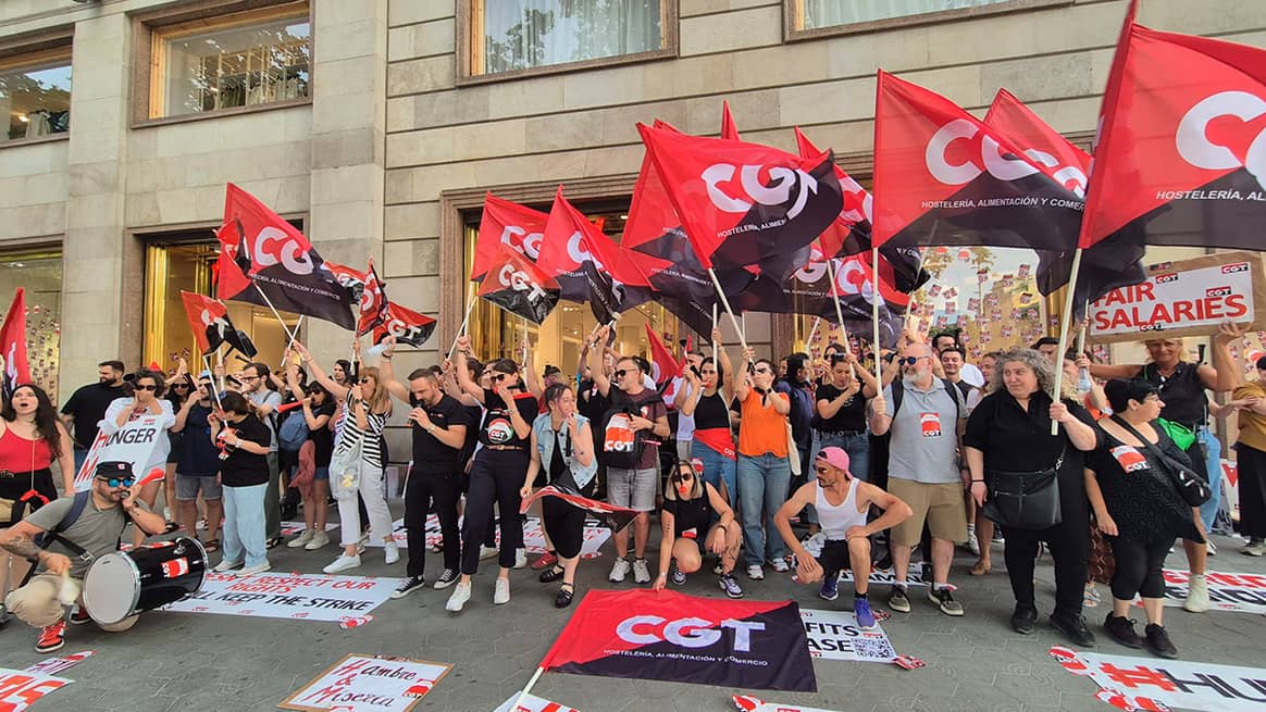 Trabajadores del centro de Atención al Cliente de H&M frente a las puertas de la tienda de la cadena en el paseo de Gracia de Barcelona (España).